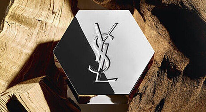 Zeshoekige YSL-parfumfles op hout.