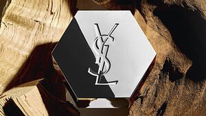 Zeshoekige YSL-parfumfles op hout.