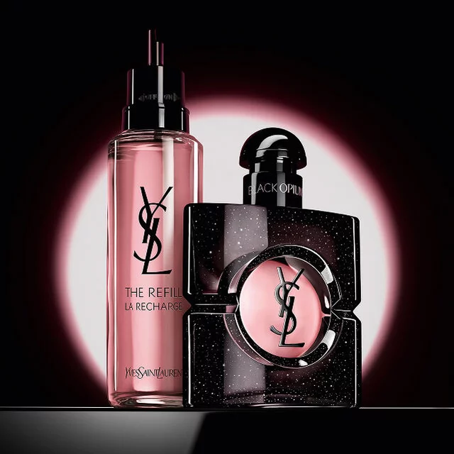 Flacon de Black Opium Eau de Parfum presente aux cotes de sa recharge en verre de 100 ml ornee du logo YSL.
