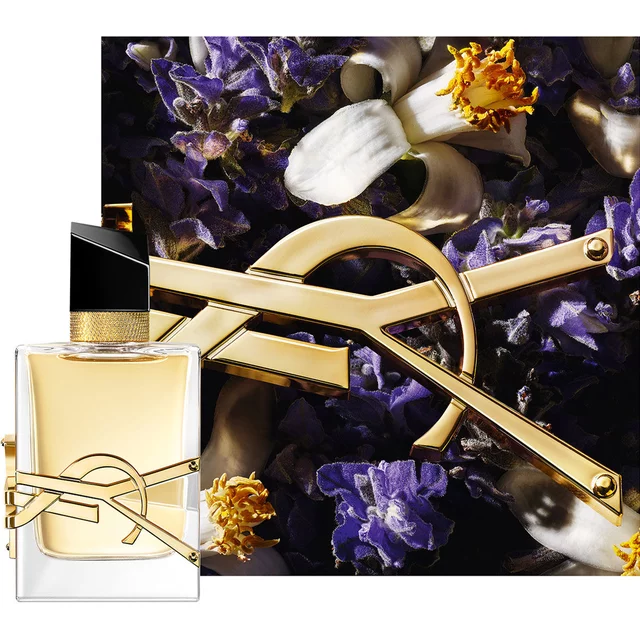 Flacon Libre Eau de Parfum stylise avec une chaine doree et des fleurs violettes sur fond sombre.