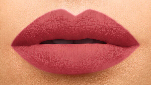 Close-up of full lips painted in a soft mauve lipstick shade, showcasing a smooth matte finish.