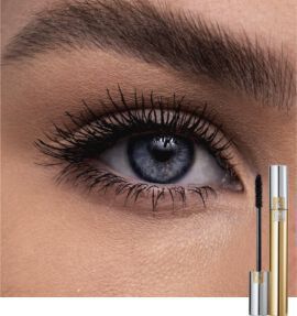 Close-up of a woman's eye with long, dark eyelashes, showcasing a striking blue iris. A tube of mascara is positioned at the bottom right corner of the image.