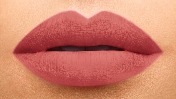 Close-up of stylized lips with a matte, soft pink lipstick.