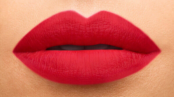 Close-up of full, bold red lips with a smooth matte finish.