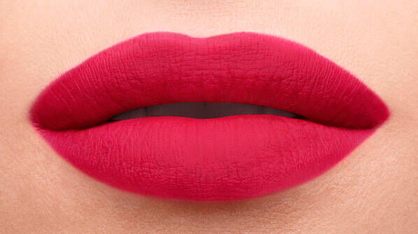 Close-up of a pair of full lips, featuring a gradient of deep red shades with a matte finish.