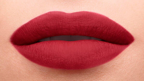 Close-up of smooth lips painted in a rich, deep red shade.