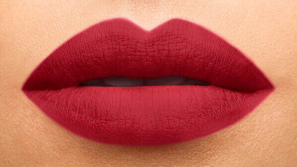 Close-up of perfectly shaped lips with a bold, matte red lipstick.
