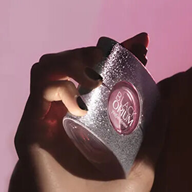 Rode YSL geschenkdoos met roze bloemen op een rode achtergrond.