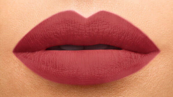 Close-up of full, well-defined lips with a matte, soft mauve lipstick, showcasing smooth texture and natural contours.