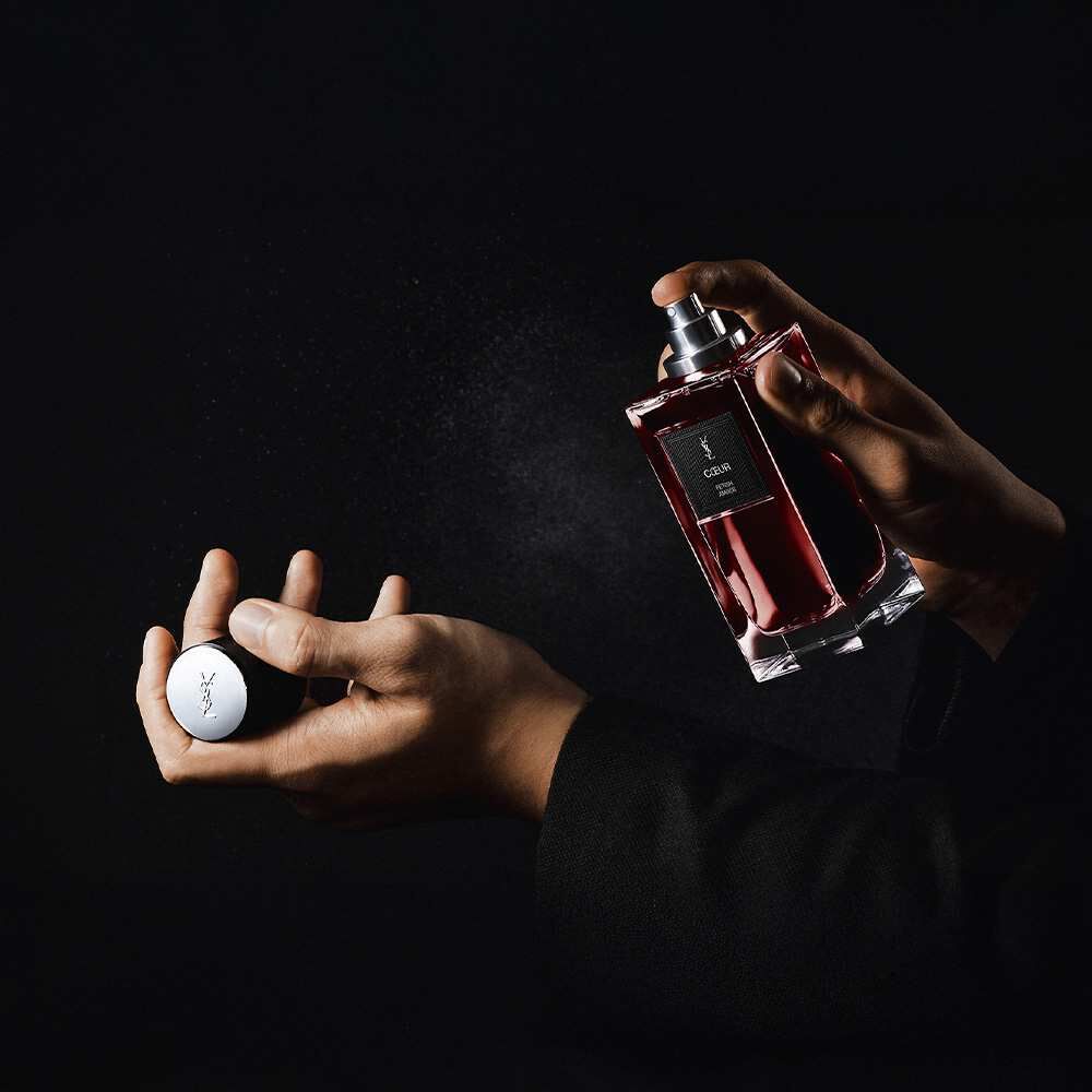 Une personne vaporise le parfum YSL « Coeur Battant » sur son poignet.​