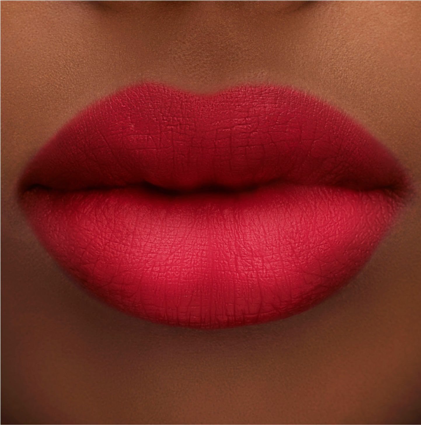 Close-up of a pair of full lips painted in a bold red matte lipstick, showcasing a smooth texture and vibrant color.
