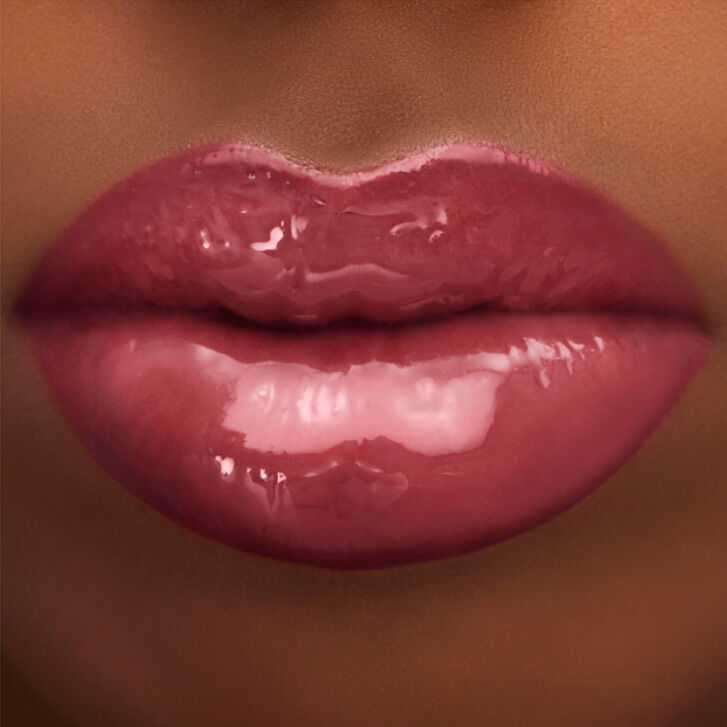 Close-up of glossy, full lips in a soft pink shade, with a smooth, shiny finish.