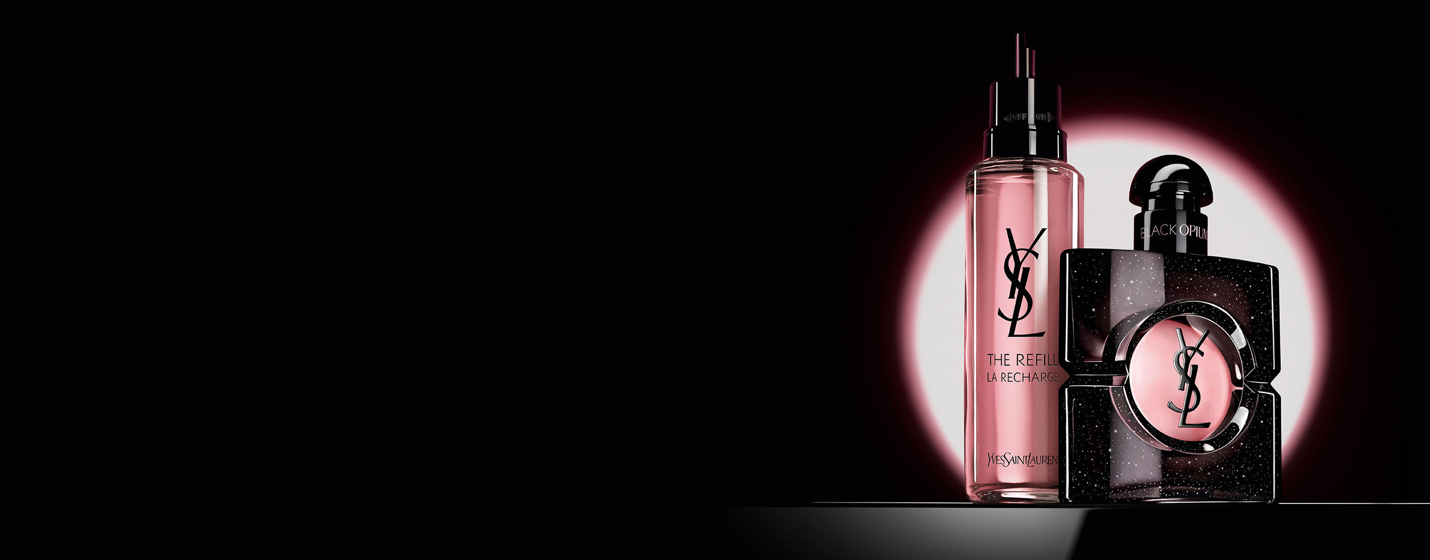 Black Opium Eau de Parfum-flacon naast de glazen navulflacon van 100 ml met het YSL-logo.
