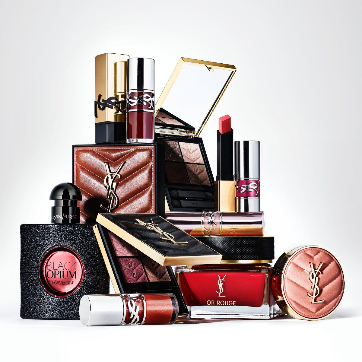 Een Yves Saint Laurent Libre parfumfles en de navulling staan op een marmeren oppervlak tegen een gemarmerde achtergrond.