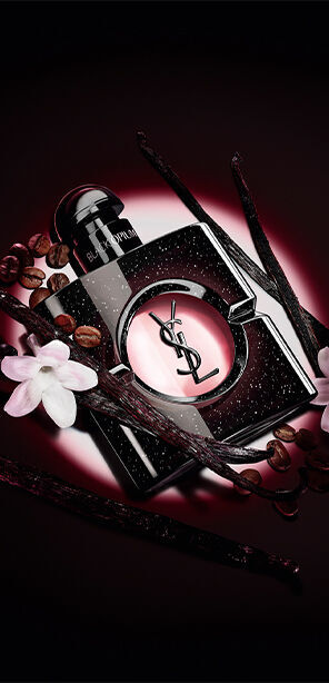 Black Opium Eau de Parfum bottle with white jasmine flowers, vanilla pods, and roasted coffee beans.