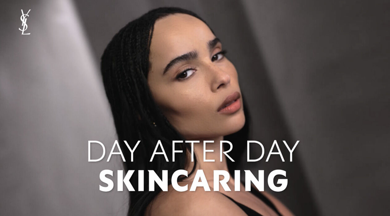 A close-up portrait of a woman with long, dark hair and a natural makeup look, accompanied by the text "DAY AFTER DAY SKINCARING" in bold white letters. The logo of YSL appears in the top left corner.