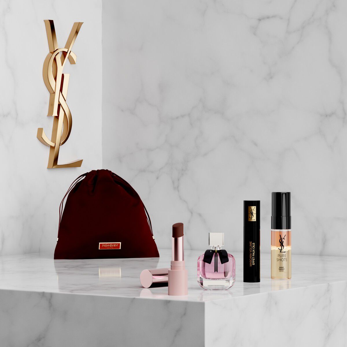 Coffret YSL Beauty avec trousse rose, rouge a levres, eyeliner, mascara et mini parfum sur etagere en marbre.