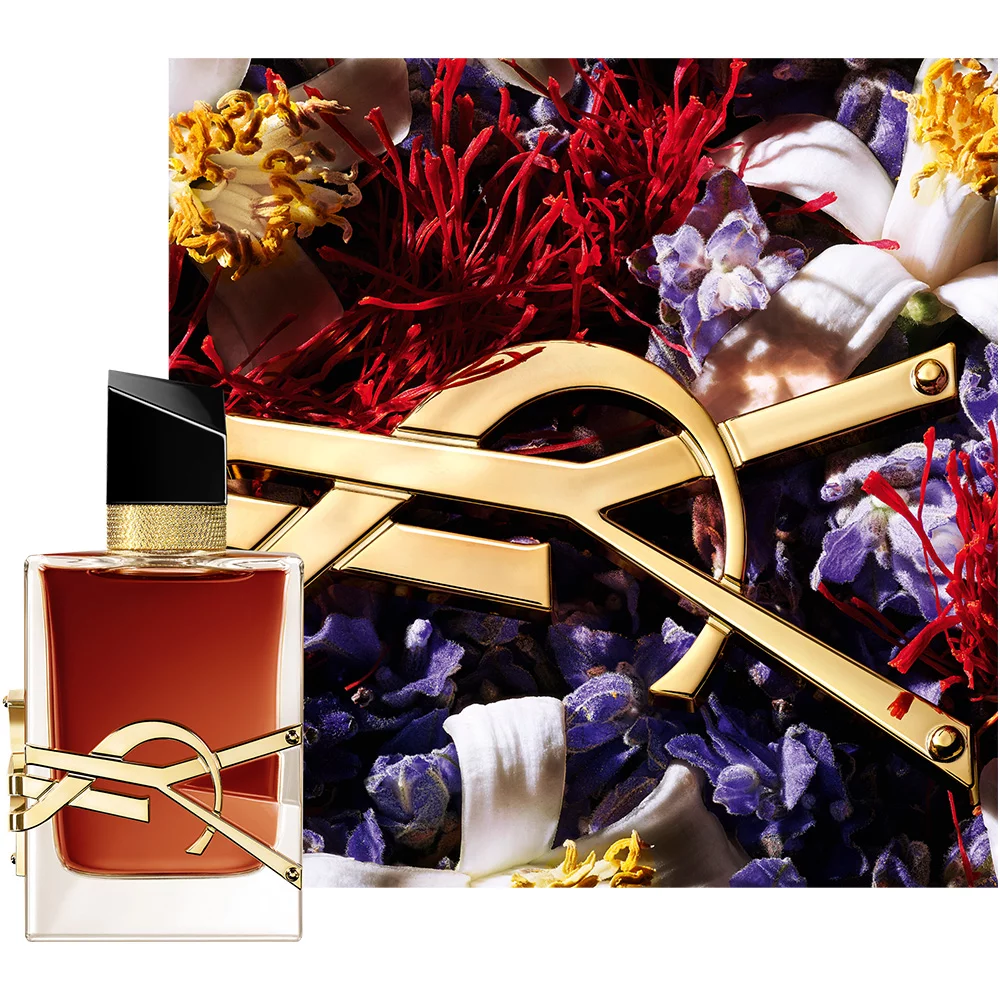 A stylish perfume bottle with a golden logo in front of a vibrant floral backdrop featuring various colorful petals and dried flowers.