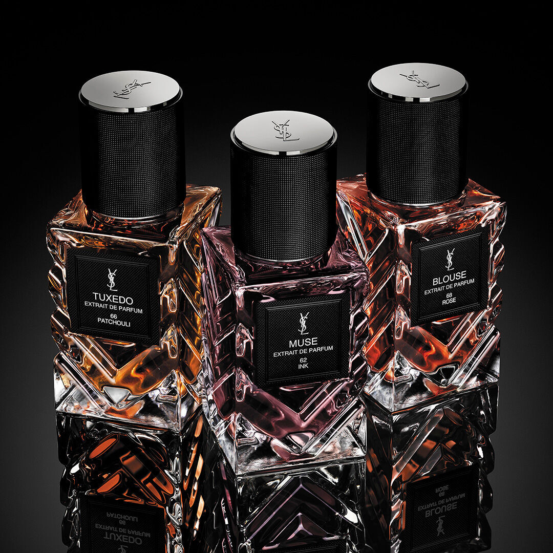 Close-up van YSL Muse extrait de parfum fles met gefacetteerd rood glas en logo.