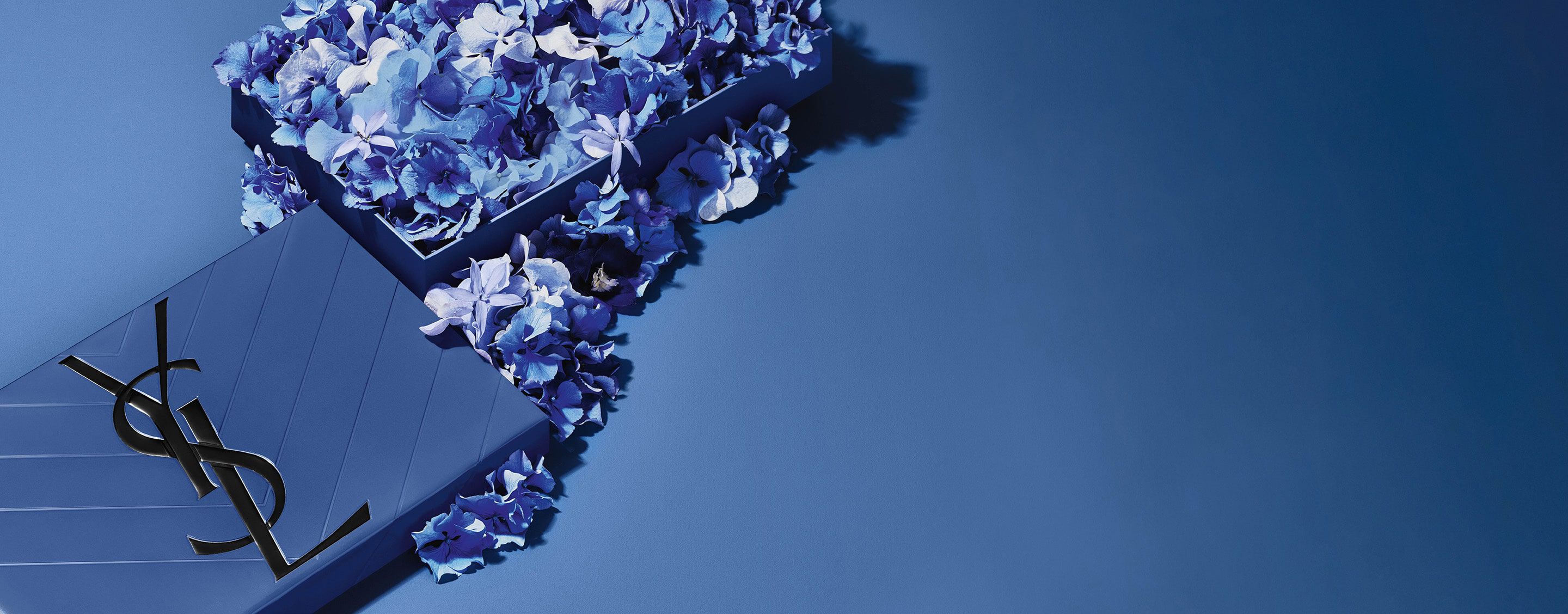 Blauwe YSL-geschenkset voor Vaderdag, met het iconische Cassandre-logo, overvloedig versierd met delicate blauwe bloemenaccenten.