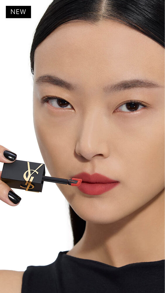 Modèle asiatique à la peau claire, appliquant une teinte rouge chaud de YSL THE INKS BLUR sur ses lèvres avec le pinceau-applicateur.