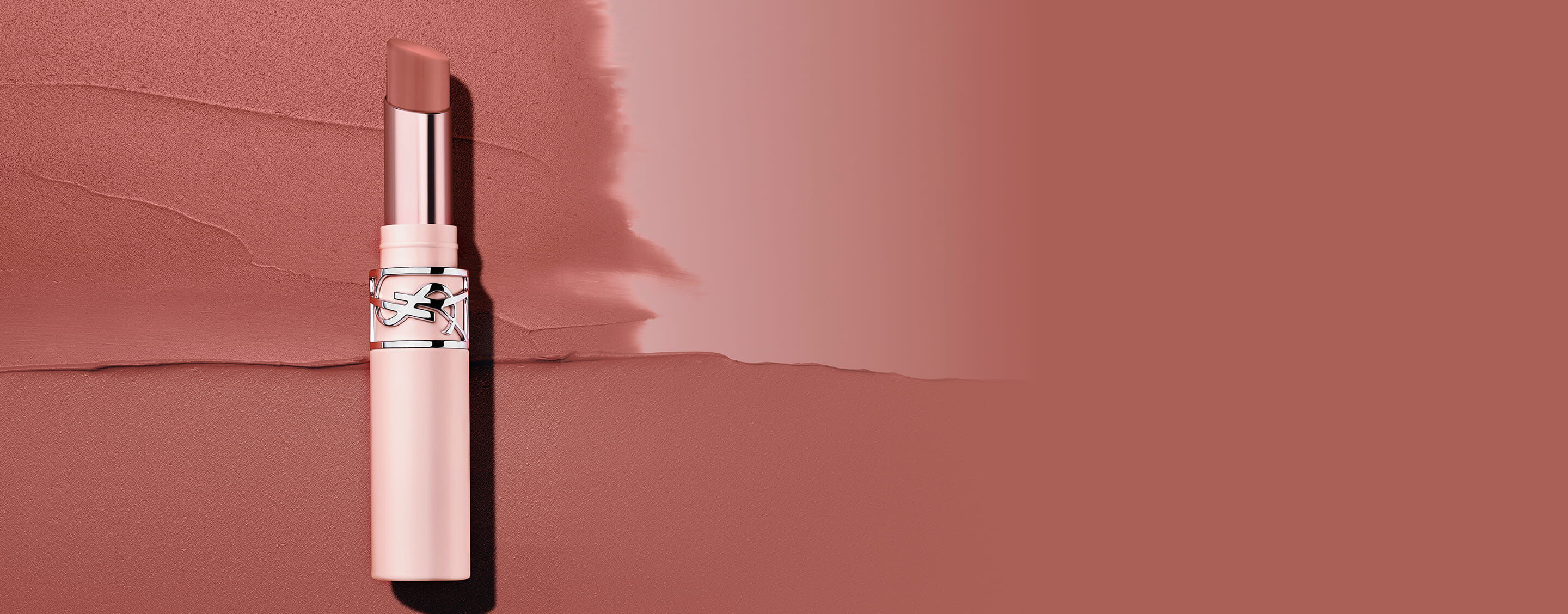 YSL LOVENUDE Lip Blusher in shade 44, standing on a textured background of two complementary nude shades.