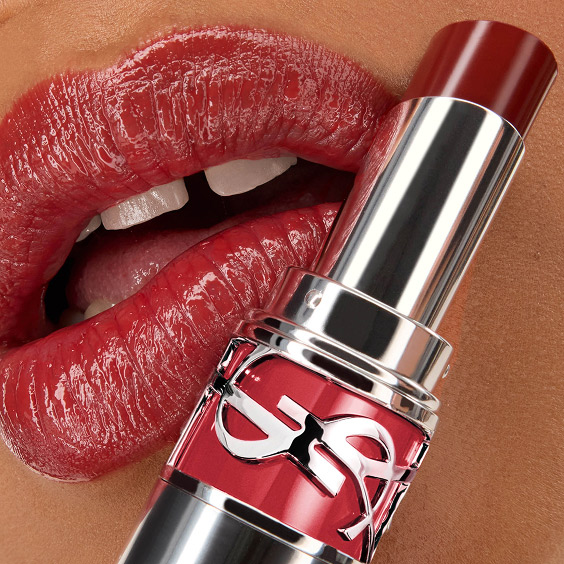 Close-up van de lippen van Mawena met YSL LOVESHINE Lipstick in de kleur 219 Berry Crush, met de lippenstift huls op de voorgrond.