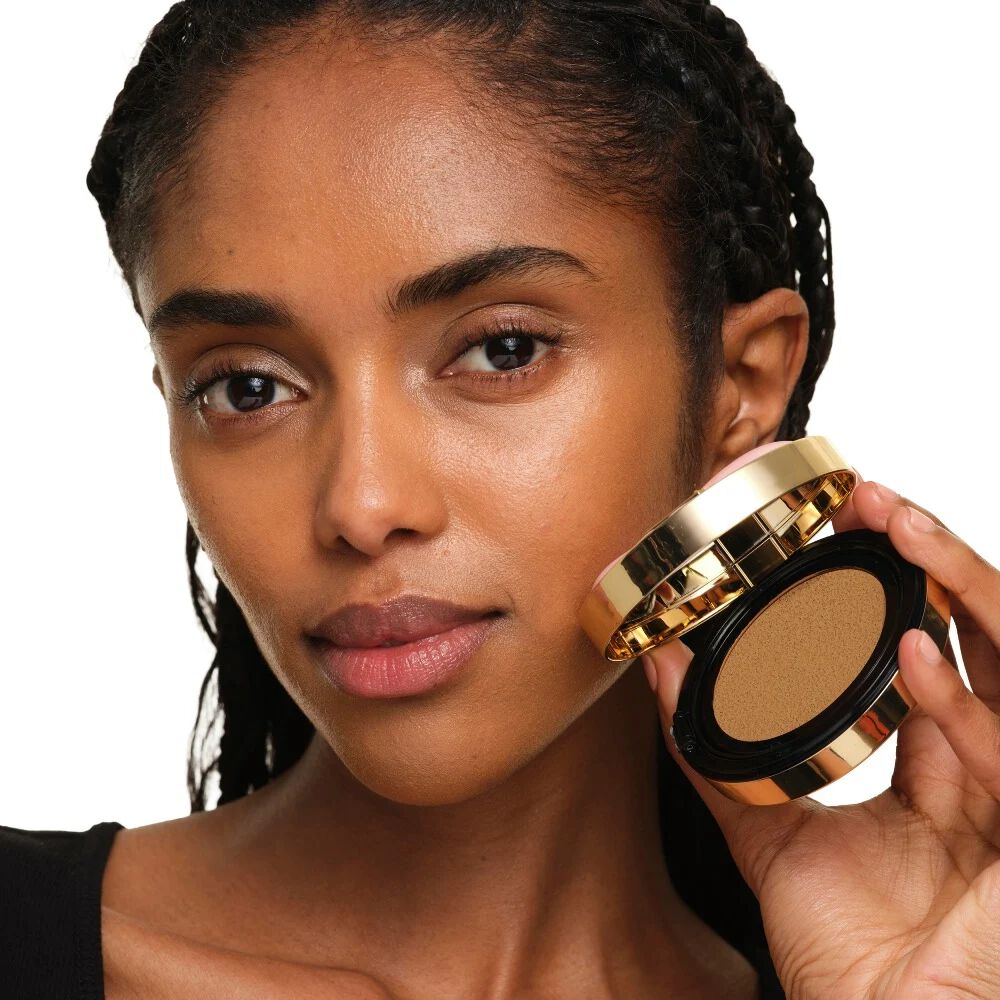 Mannequin à la peau moyenne tenant le YSL SKIN AFFAIR SOFT GLOW CUSHION. Teint lumineux, uniforme et au naturel.