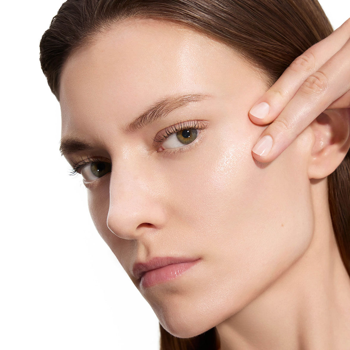 Marije, modèle YSL Beauty, avec une peau claire, touchant doucement sa joue, montrant une peau lisse après l'application de la lotion.