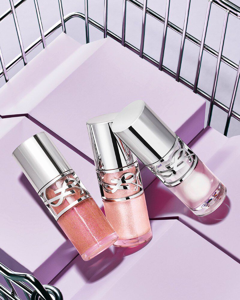 Trois YSL Loveshine teintes 10, 11 et 12 présentés sur des blocs violets dans un panier métallique.