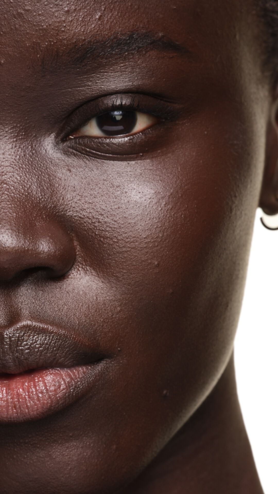 Résultat sur peau foncée avec YSL SKIN AFFAIR FOUNDATION. Gros plan montrant un teint éclatant, lisse et parfaitement unifié.