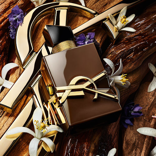 La Cassandre YSL dorée repose sur un bois de santal brut, parée de fleurs d’oranger blanches et de lavande, avec un texte qui évoque la sensualité, la vibration et l’énergie du bois de santal.