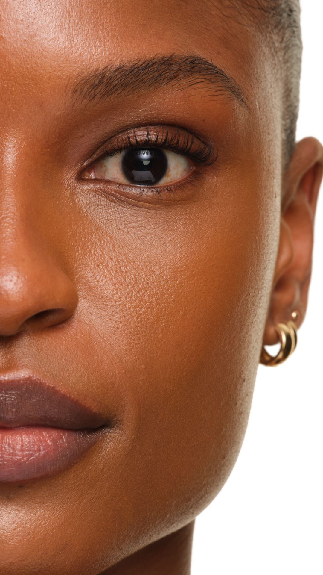Finition éclatante de YSL SKIN AFFAIR FOUNDATION sur peau foncée. Zoom extrême montrant une texture lisse, lumineuse et sans pores.