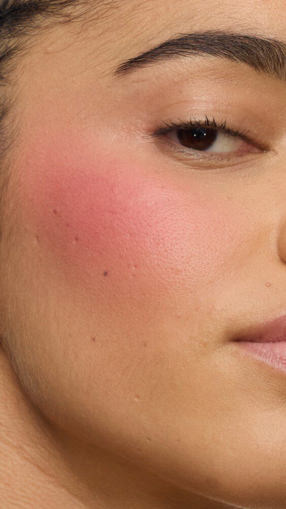 Close-up van een model met de Make Me Blush-routine: Powder #54 Berry Bang gelayerd met Cream #44 Nude Lavallière voor een levendig, custom pink statement.