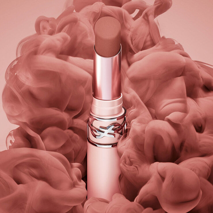 YSL LOVENUDE Lip Blusher in shade 7, open, surrounded by ethereal pink and nude pigment clouds.